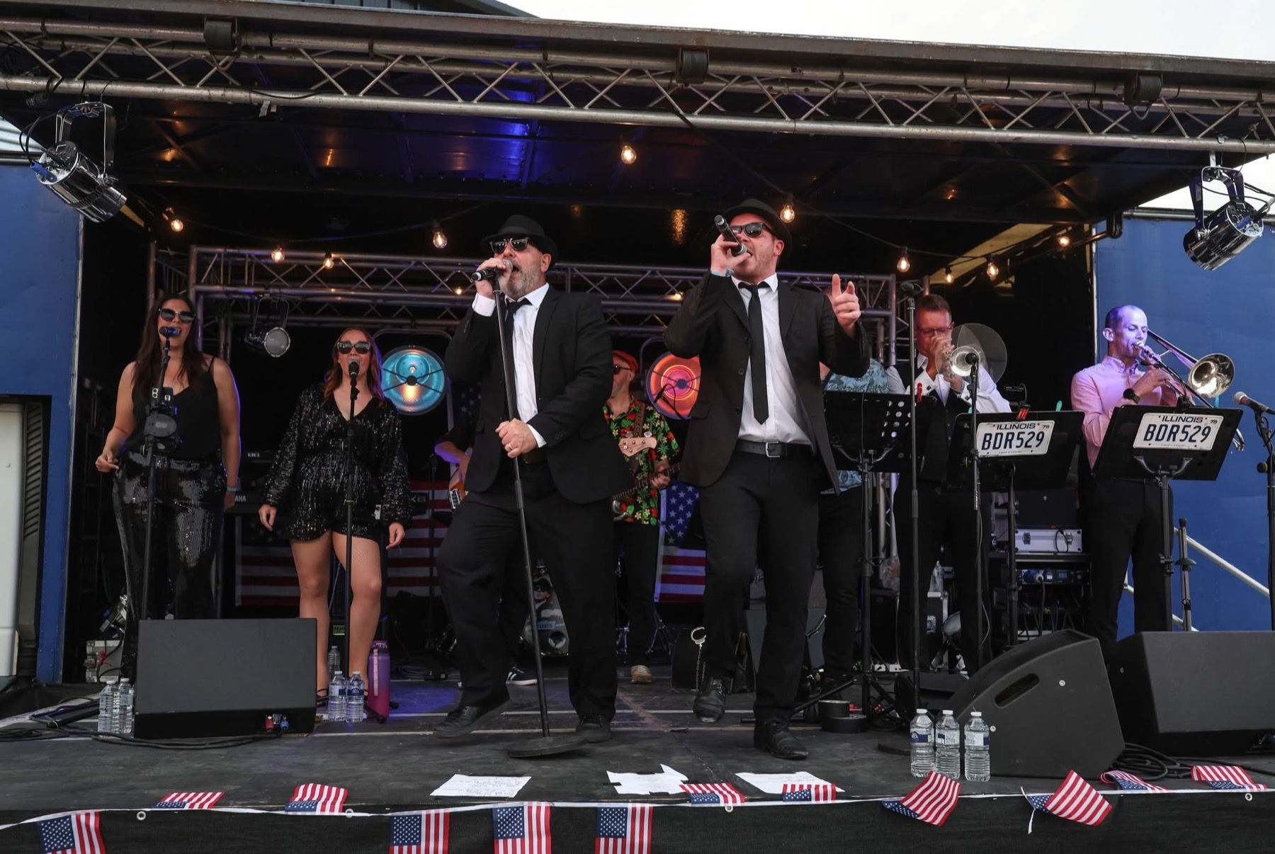The full band performing on an outdoor festival stage